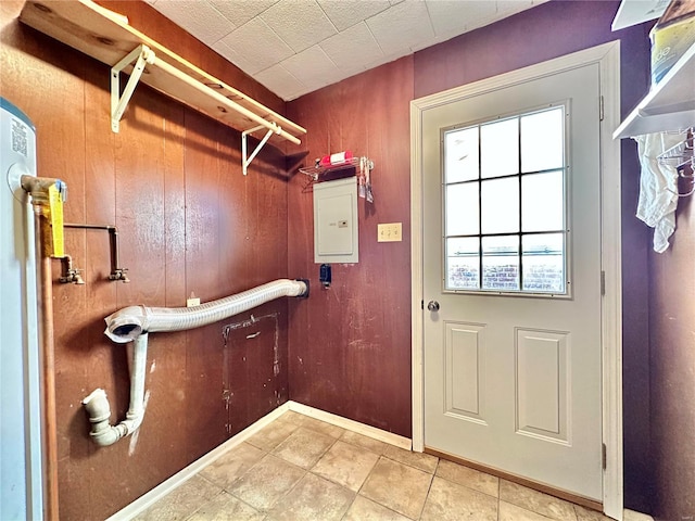 entryway with light tile patterned floors, electric panel, and wood walls