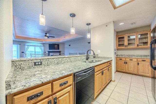 kitchen with pendant lighting, a raised ceiling, sink, ceiling fan, and black dishwasher