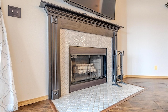 room details with a tile fireplace and wood-type flooring