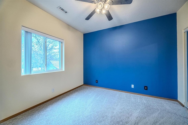 carpeted spare room with ceiling fan