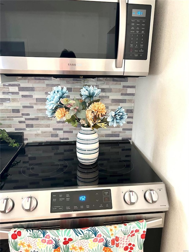 room details featuring tasteful backsplash and appliances with stainless steel finishes