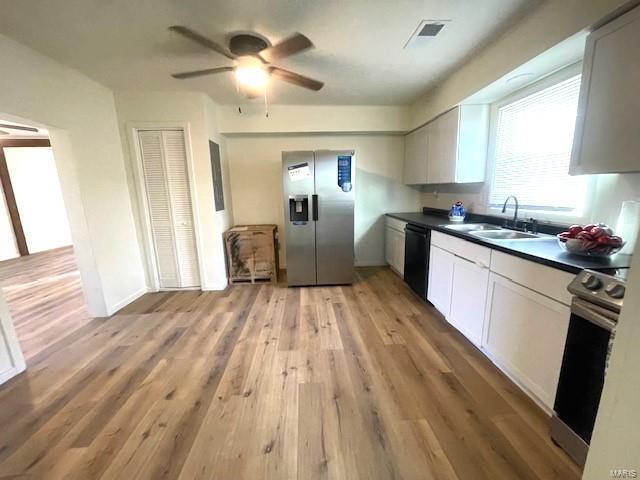 kitchen featuring white cabinetry, sink, stainless steel appliances, and light hardwood / wood-style floors