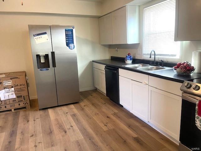 kitchen with white cabinetry, sink, light hardwood / wood-style floors, and appliances with stainless steel finishes