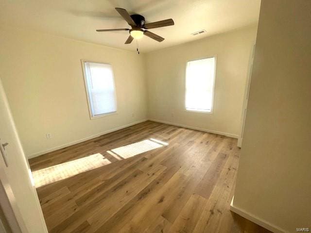 unfurnished room featuring ceiling fan, light hardwood / wood-style floors, and a wealth of natural light