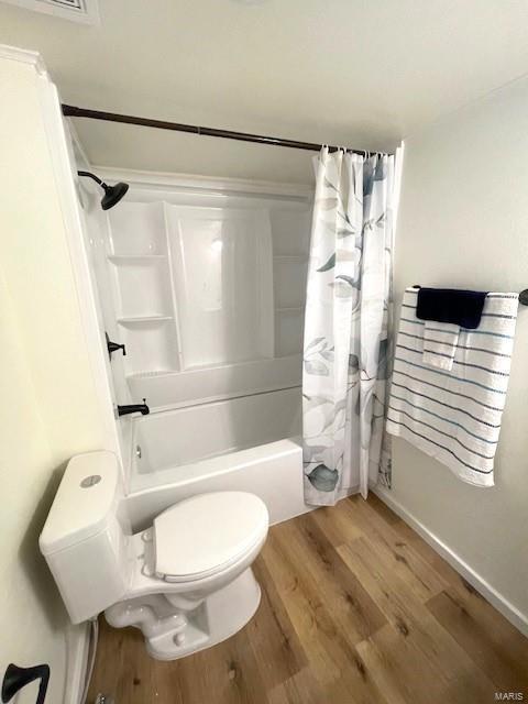 bathroom featuring shower / bathtub combination with curtain, wood-type flooring, and toilet