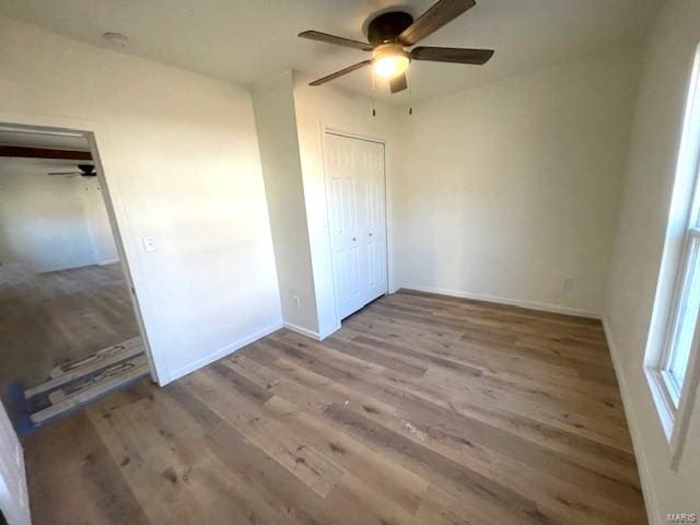 unfurnished bedroom featuring ceiling fan, hardwood / wood-style floors, and a closet