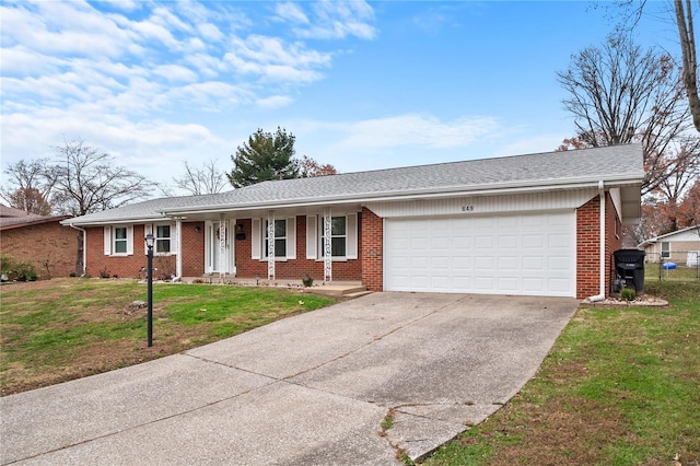 ranch-style house with covered porch, a front yard, and a garage