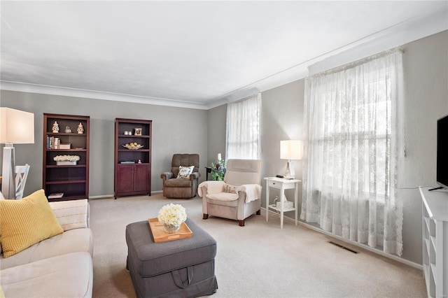 carpeted living room featuring ornamental molding