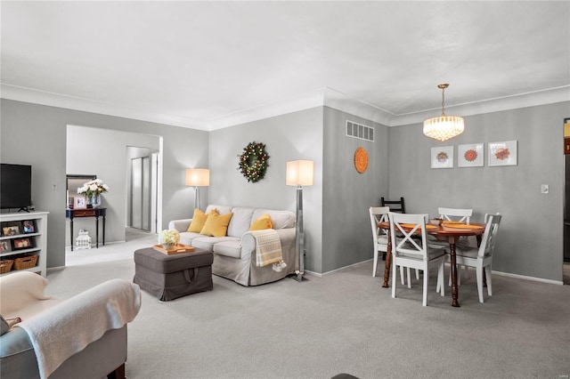 carpeted living room featuring a notable chandelier and ornamental molding