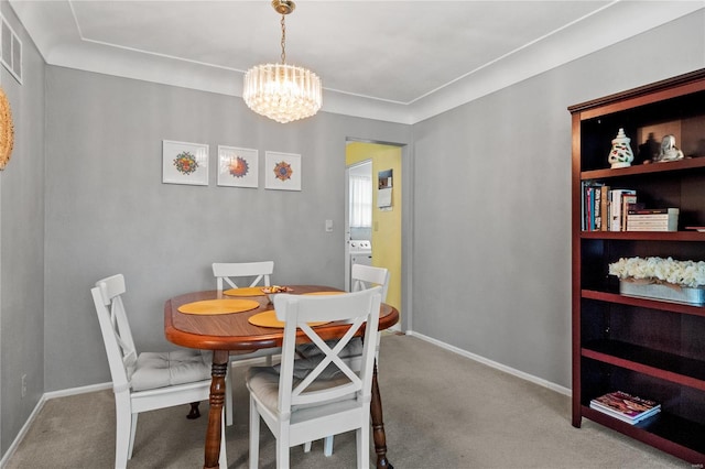 carpeted dining area featuring a chandelier