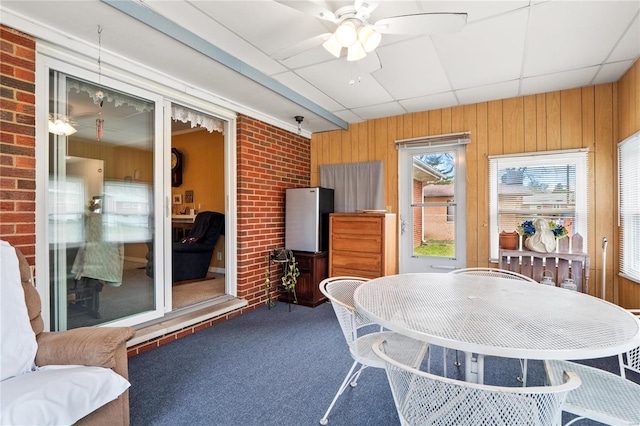 sunroom with a paneled ceiling and ceiling fan