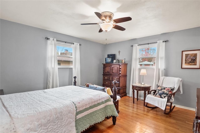 bedroom with multiple windows, ceiling fan, and light hardwood / wood-style flooring