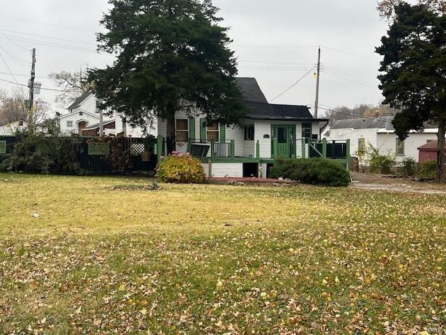 view of front of house with a deck and a front lawn