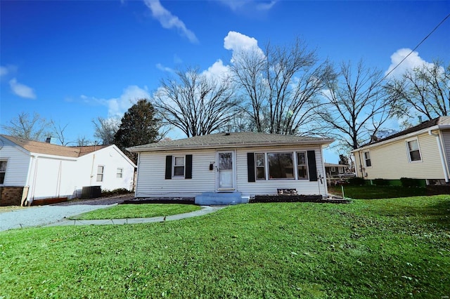 view of front of home with central AC unit and a front yard