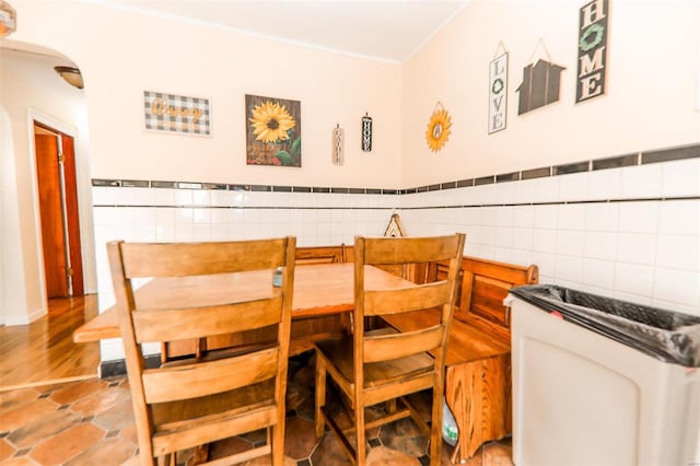 dining area with hardwood / wood-style floors and tile walls