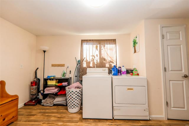 laundry room featuring washer and clothes dryer and light hardwood / wood-style flooring