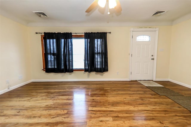 foyer with wood finished floors, visible vents, and baseboards