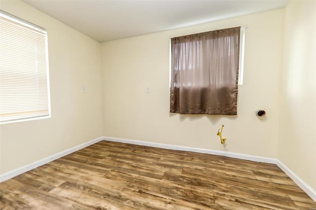 spare room featuring baseboards and wood finished floors