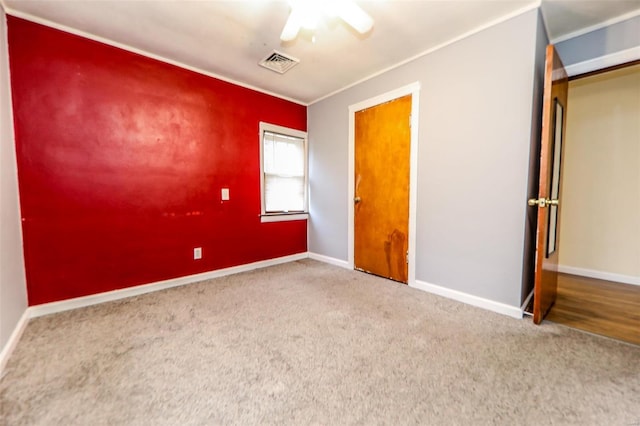 unfurnished bedroom featuring carpet floors, baseboards, visible vents, and a ceiling fan