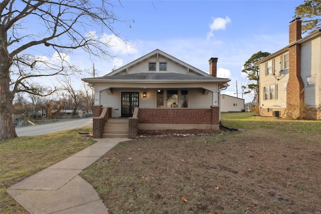 bungalow-style home with a porch and a front lawn