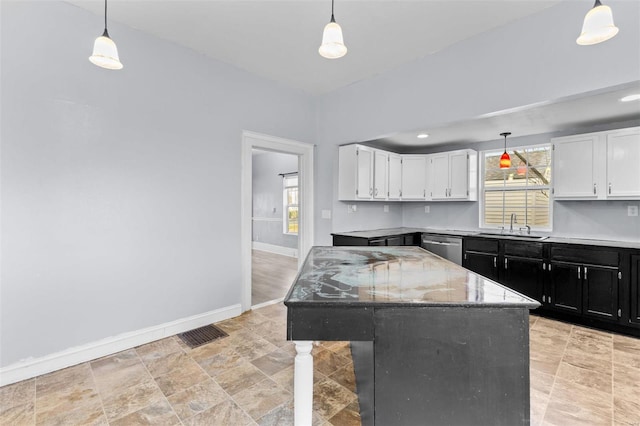 kitchen featuring dishwasher, a center island, sink, decorative light fixtures, and white cabinets