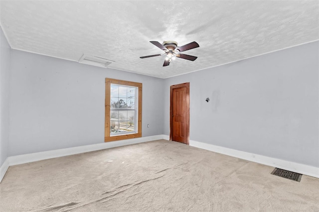 spare room featuring carpet flooring, ceiling fan, and a textured ceiling