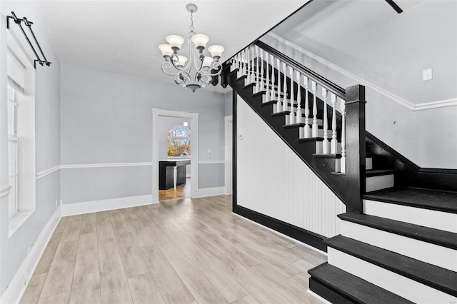 staircase featuring wood-type flooring and an inviting chandelier