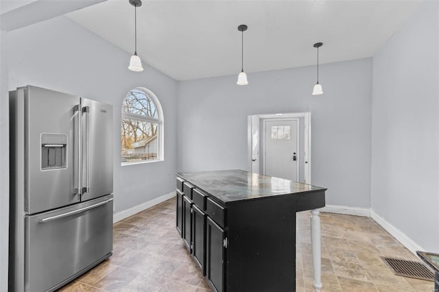 kitchen with high end refrigerator, a center island, pendant lighting, and vaulted ceiling