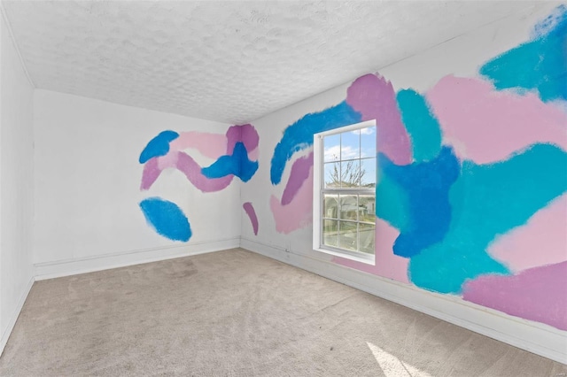 spare room featuring carpet floors and a textured ceiling