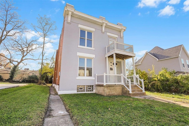 view of front of house with a balcony and a front lawn