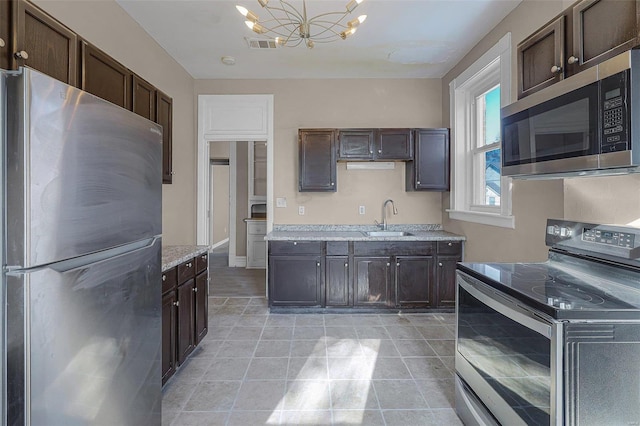 kitchen with sink, an inviting chandelier, decorative light fixtures, dark brown cabinets, and appliances with stainless steel finishes