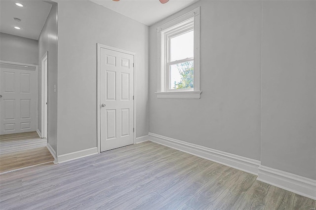 spare room with ceiling fan and light wood-type flooring