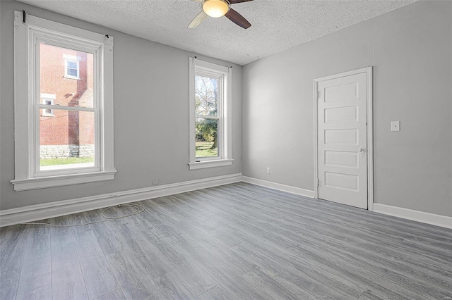 unfurnished room featuring ceiling fan, light hardwood / wood-style floors, and a textured ceiling