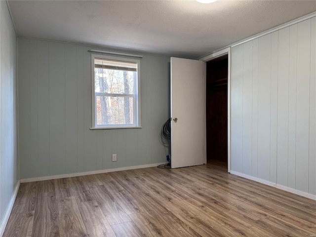 empty room featuring a textured ceiling and light wood-type flooring