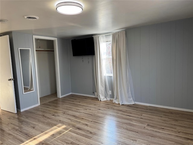 unfurnished bedroom with light hardwood / wood-style floors and a closet