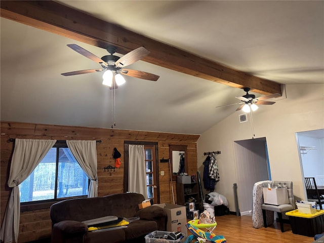 living room featuring ceiling fan, lofted ceiling with beams, wood-type flooring, and wooden walls