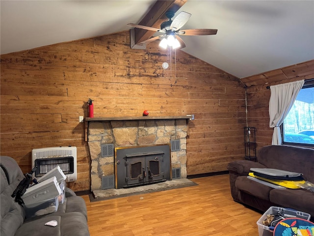 living room with wood walls, lofted ceiling with beams, ceiling fan, light hardwood / wood-style floors, and heating unit