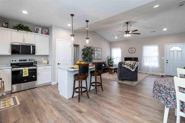 kitchen featuring hanging light fixtures, appliances with stainless steel finishes, and white cabinetry