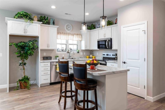 kitchen featuring white cabinetry, sink, appliances with stainless steel finishes, and a kitchen island