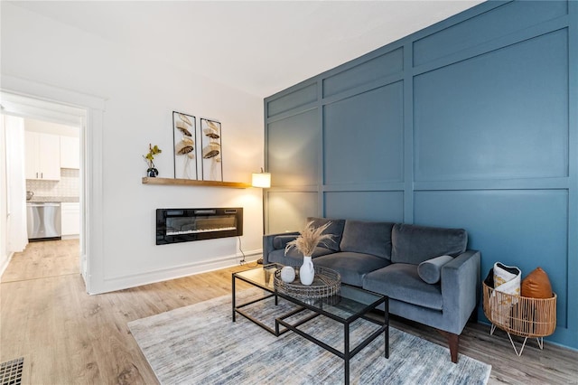 living room featuring heating unit and light wood-type flooring