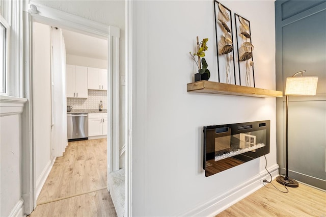 hallway featuring sink and light hardwood / wood-style floors