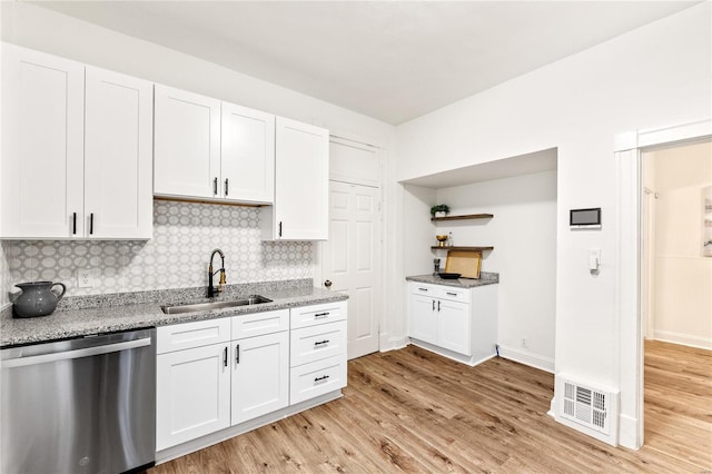 kitchen featuring dishwasher, backsplash, sink, light wood-type flooring, and white cabinetry