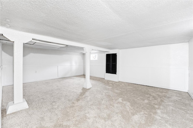 basement with carpet flooring and a textured ceiling