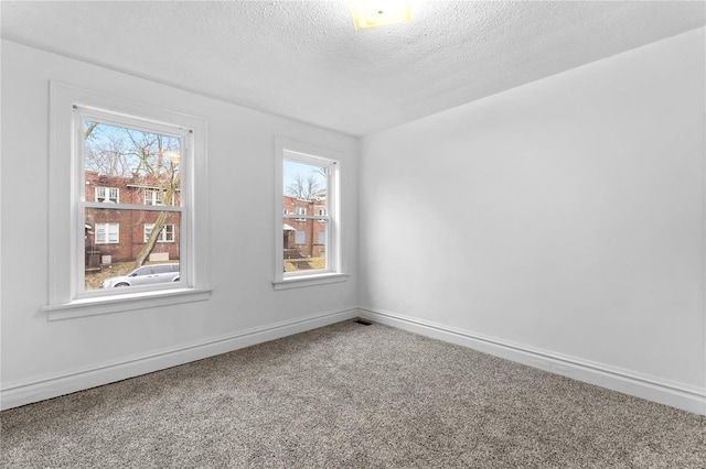 unfurnished room featuring carpet and a textured ceiling