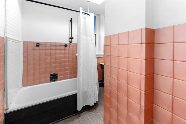 bathroom with tile patterned flooring, tile walls, and shower / bath combo with shower curtain