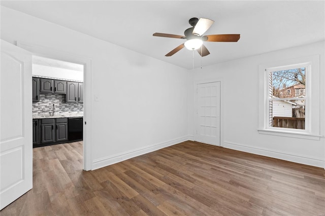 empty room featuring ceiling fan, sink, and light hardwood / wood-style floors