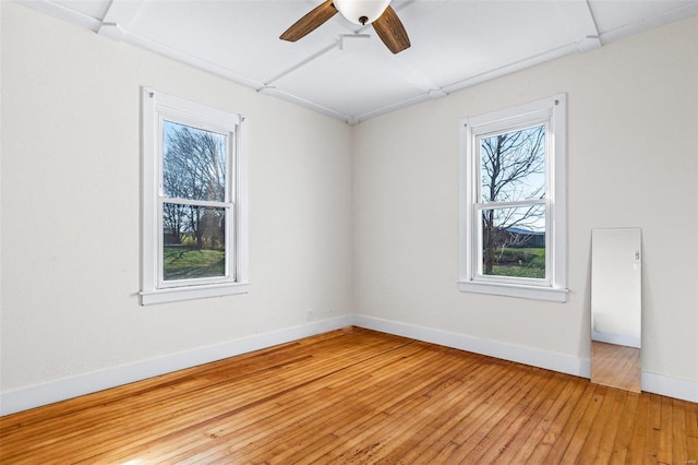 empty room with hardwood / wood-style floors, plenty of natural light, and ceiling fan