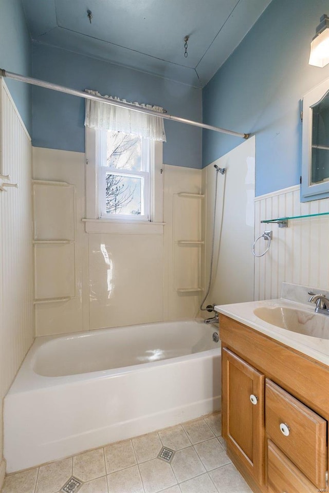 bathroom with tile patterned flooring, vanity, and  shower combination