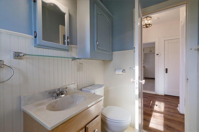 bathroom with vanity, hardwood / wood-style flooring, toilet, and a notable chandelier