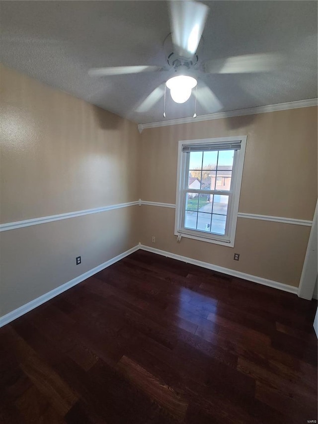 unfurnished room with ceiling fan, dark hardwood / wood-style flooring, and ornamental molding